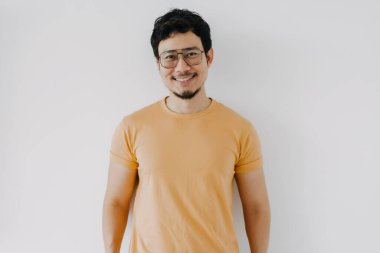 Sarı tişörtlü ve gözlüklü Asyalı beyaz tenli mutlu titreşimler..