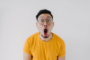Şaşırmış yüz ifadesi Asyalı adam sarı gözlüklü beyaz tenli..
