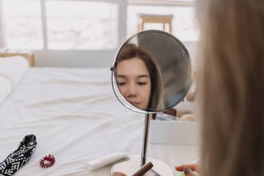 Aynada makyaj yapan Asyalı kadın. Alet edevat ve teçhizatla..