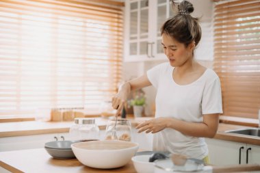 Asyalı kadın mutfakta yemek pişiriyor ve kocaya erişte hazırlıyor..