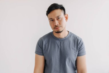 Mavi tişörtlü Asyalı adamın sıkılmış ve yargılanmış yüzü beyazlar içinde izole edilmiş..