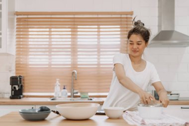 Asyalı kadın mutfakta yaptığı yemekleri kontrol ediyor..