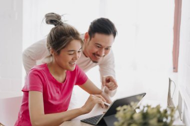 Asyalı karı koca online reklam hakkında tartışıyor ve planlıyorlar.