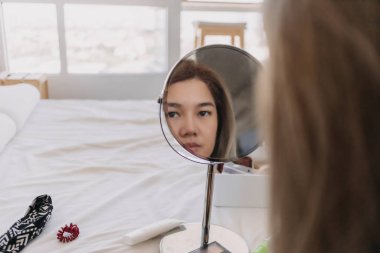 Aynada makyaj yapan Asyalı kadın. Alet edevat ve teçhizatla..