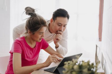 Asyalı çift aşığı birbirine problemi çözmeyi ve online çalışmayı öğretiyor..