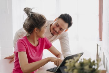 Asyalı çift aşığı birbirine problemi çözmeyi ve online çalışmayı öğretiyor..