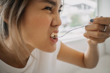 Kafede pasta yiyen komik Asyalı kadın yüzünü kapat..