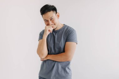 Utangaç ve utanç verici mavi tişörtlü komik Asyalı beyaz duvarda izole edilmiş..