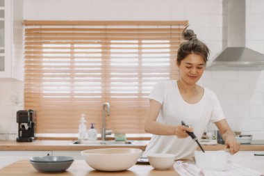 Asyalı kadın servis edilecek çorbayı getiriyor..