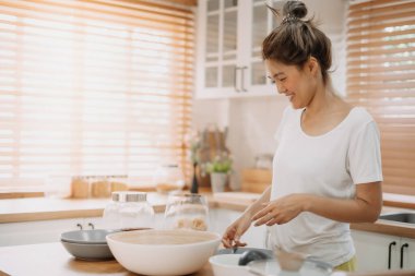 Asyalı bir kadın mutfakta basit erişte pişirmekten zevk alır..