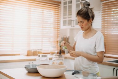 Asyalı kadın mutfakta yemek pişiriyor ve kocaya erişte hazırlıyor..