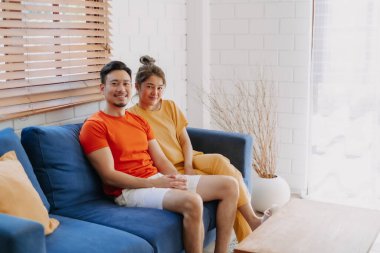 Sevgili Asyalı çift aşığı sıcak evdeki kanepede birlikte oturuyorlar..