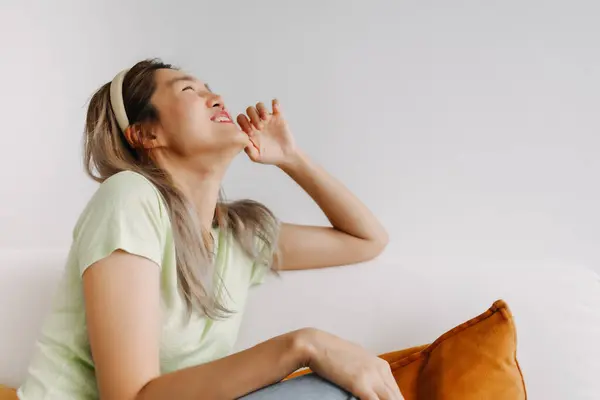 stock image Laugh and happy asian woman alone on the sofa. Good vibes and chill mood.