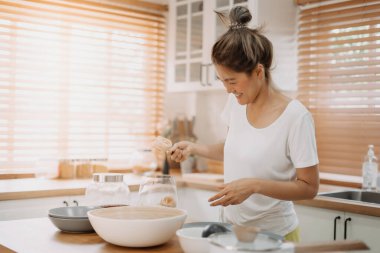 Asyalı bir kadın mutfakta basit erişte pişirmekten zevk alır..