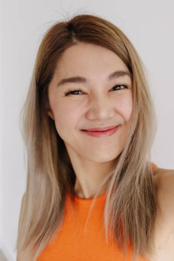 Asyalı bir kadının beyaza izole edilmiş bir şekilde selfie çektiği dikey fotoğraf..