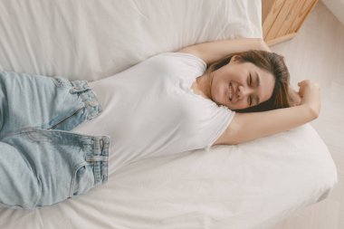 Çekici Asyalı kadın kaygısız bir günde evinde kanepeye uzanıyor..