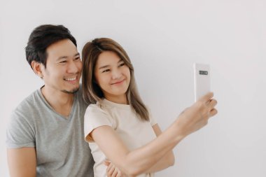 Mutlu komik Asyalı kadın beyaz tenli erkek arkadaşıyla selfie çektirdi..