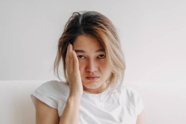 Baş ağrısı çeken, akşamdan kalma, eli başı örtülü bir Asyalı kadının fotoğrafını çek..