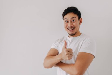 Asyalı adamın mutlu, gülen yüzü beyaz arka planda izole edilmiş beyaz tişört giyiyor..