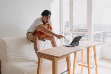 Komik Asyalı adam işinden çok mutlu ve heyecanlı. Bilgisayar tabletindeki başarısı ve zaferi..