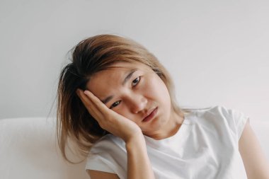 Baş ağrısı çeken, akşamdan kalma, eli başı örtülü bir Asyalı kadının fotoğrafını çek..