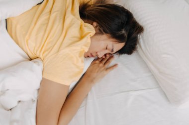 Yorgun ve hasta bir Asyalı kadın evde derin bir uykuya daldı..