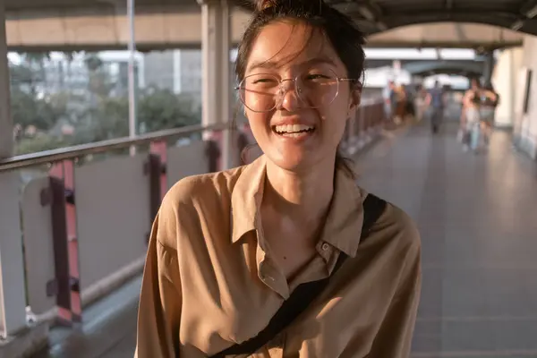 Ordinary happy asian salary woman walking on city bridge urban scene.