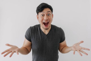 Siyah tişörtlü Asyalı adam beyaz duvarda tek başına duruyor..