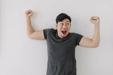 Mutlu ve neşeli yüzlü siyah tişörtlü Asyalı adam beyaz arka planda izole edilmiş..