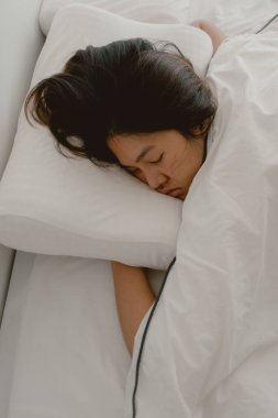 Asyalı Taylandlı kadının gözlerini kapattığı, beyaz yatakta uyuduğu, sabahları beyaz battaniyeyle sarmaladığı.... 