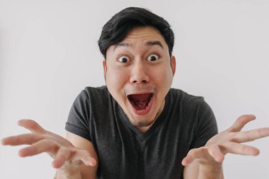 Siyah tişörtlü Asyalı adam beyaz duvarda tek başına duruyor..