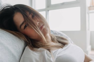 Asyalı üzgün kadın sıkıcı bir günde yerde oturuyor. Sıkıldım ve hayattan yoruldum..