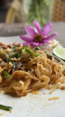 Pad Thai 'nin çatalla yendiğini gösteren dikey video..