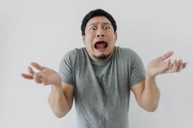 Beyaz tişörtlü Asyalı adamın şok olmuş ve hayal kırıklığına uğramış yüzü..