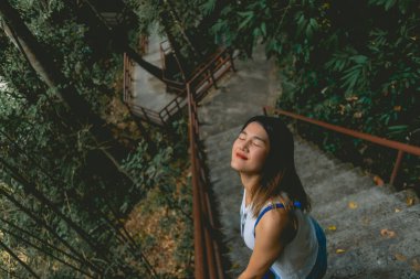 Mutlu Asyalı kadın Tayland 'daki tropikal orman koruma parkının tadını çıkarıyor..