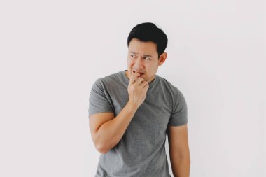 Üzgün ve bunalımlı, gri tişörtlü, beyaz tişörtlü, mütevazı Asyalı adam..