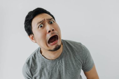 Beyaz tişörtlü Asyalı adamın şok olmuş ve hayal kırıklığına uğramış yüzü..