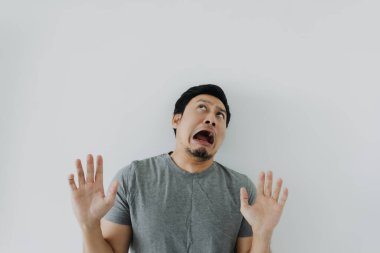 Beyaz tişörtlü Asyalı adamın şok olmuş ve hayal kırıklığına uğramış yüzü..