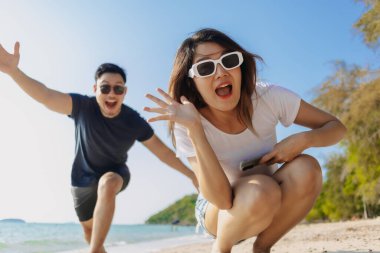 Sahilde birlikte fotoğraf çeken Asyalı oyuncu çift aşıklar..