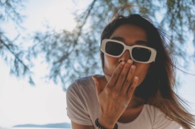 Sahilde olmaktan mutluluk duyan neşeli Asyalı kadını yakından çek..