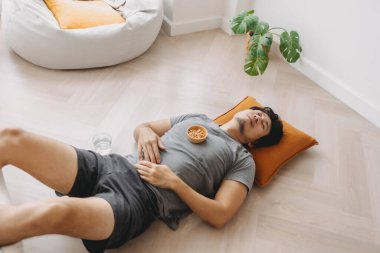 Asyalı adam hafta sonu çerez yerken yerde uyuyakalıyor..