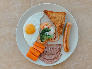Beyaz masada kızarmış yumurta, tost, havuç ve jambon..