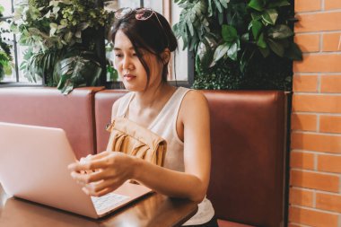 Asyalı kadın işini bitirdi ve dizüstü bilgisayarını kapattı..