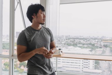 Asyalı bir adam sabah pencerede fıstık yiyor..