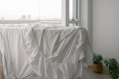 Beyaz çarşaflar dairenin balkonunda yıkandıktan sonra sarkıyor...