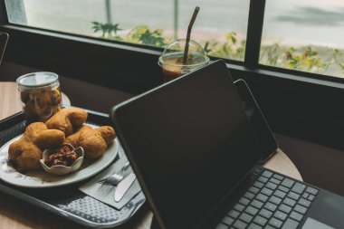 Bilgisayar tableti, tatlı ve buzlu içecek. Bir kafede çalışma kavramı.