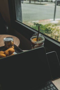 Bilgisayar tableti, tatlı ve buzlu içecek. Bir kafede çalışma kavramı.