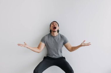 Beyaz arka planda gri giyinmiş Asyalı adam. Tüm vücut Portresi.