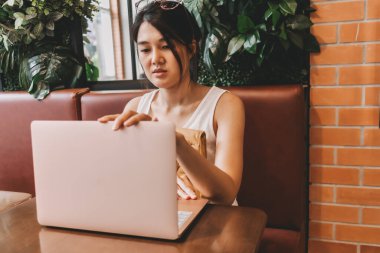 Asyalı kadın işini bitirdi ve dizüstü bilgisayarını kapattı..