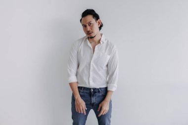 Üzgün surat, uzun saçlı, beyaz gömlekli Asyalı adam çöreği ve beyaz kot pantolon..